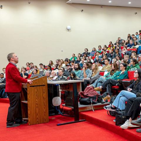 Corey Ryan Earle ’07, the university’s longtime unofficial historian, speaks to a full house in his “Last Lecture” Dec. 4 in Uris Hall Auditorium.