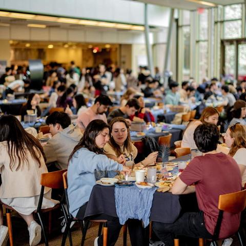 Dozens of students around tables in a dining room