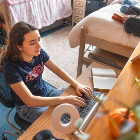 Female student working at desk in residence hall.