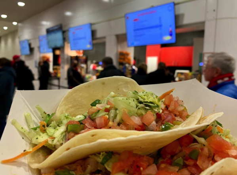 Two soft shell tacos with lettuce and tomatoes.