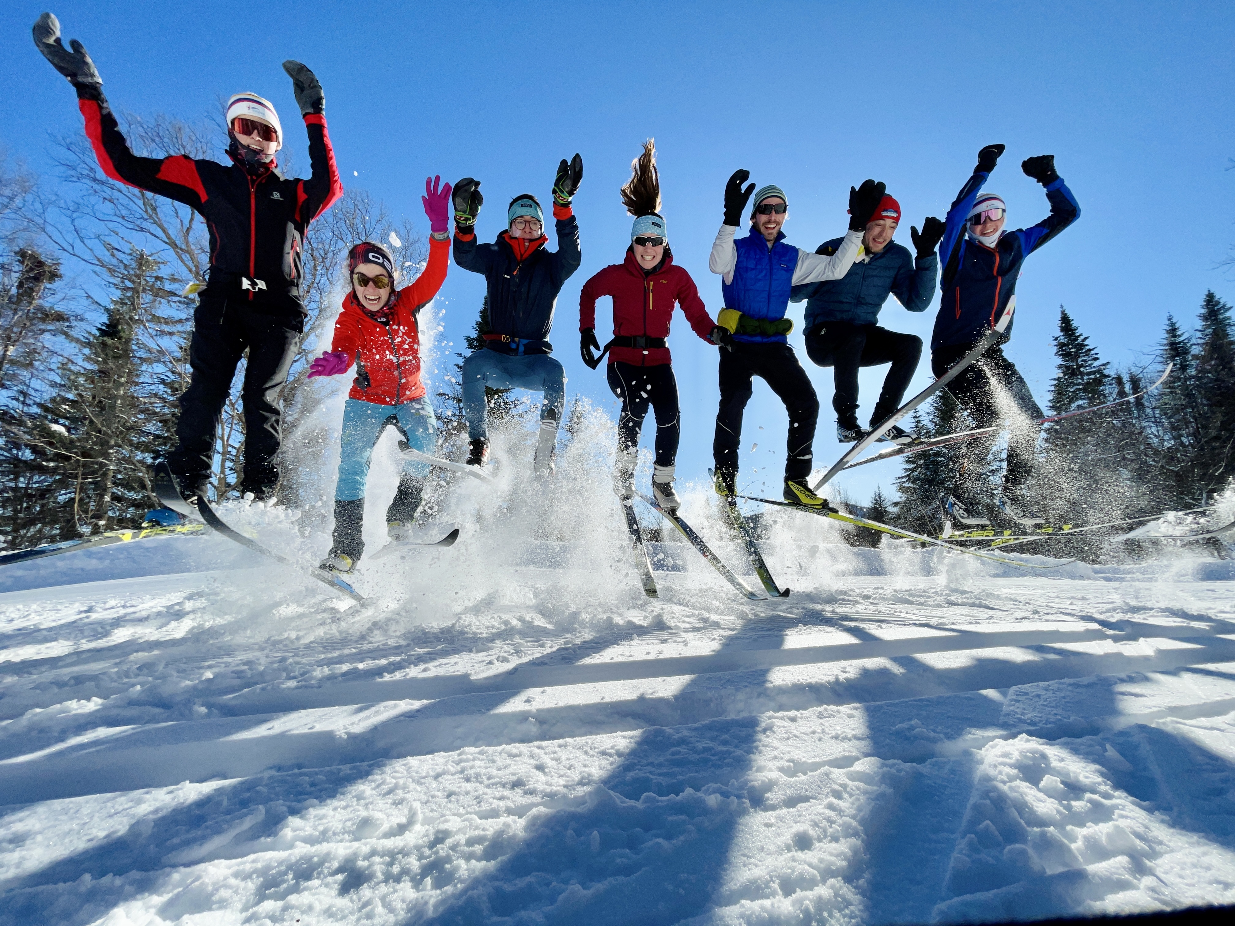 Members of the Cross-Country Skiing Club jump in the air.