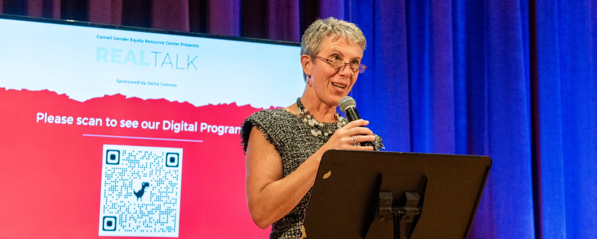 Woman speaks into a microphone at a podium