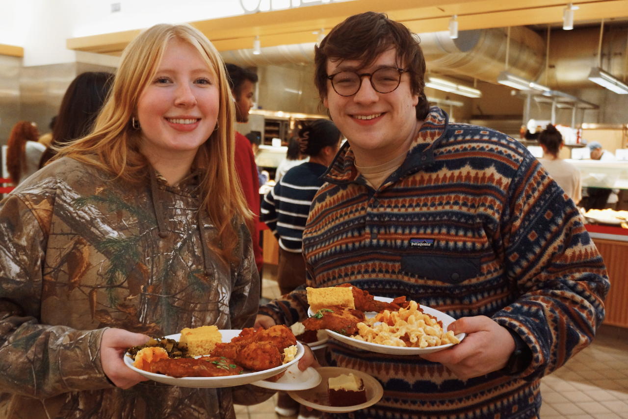 Students smiling holding plates of food