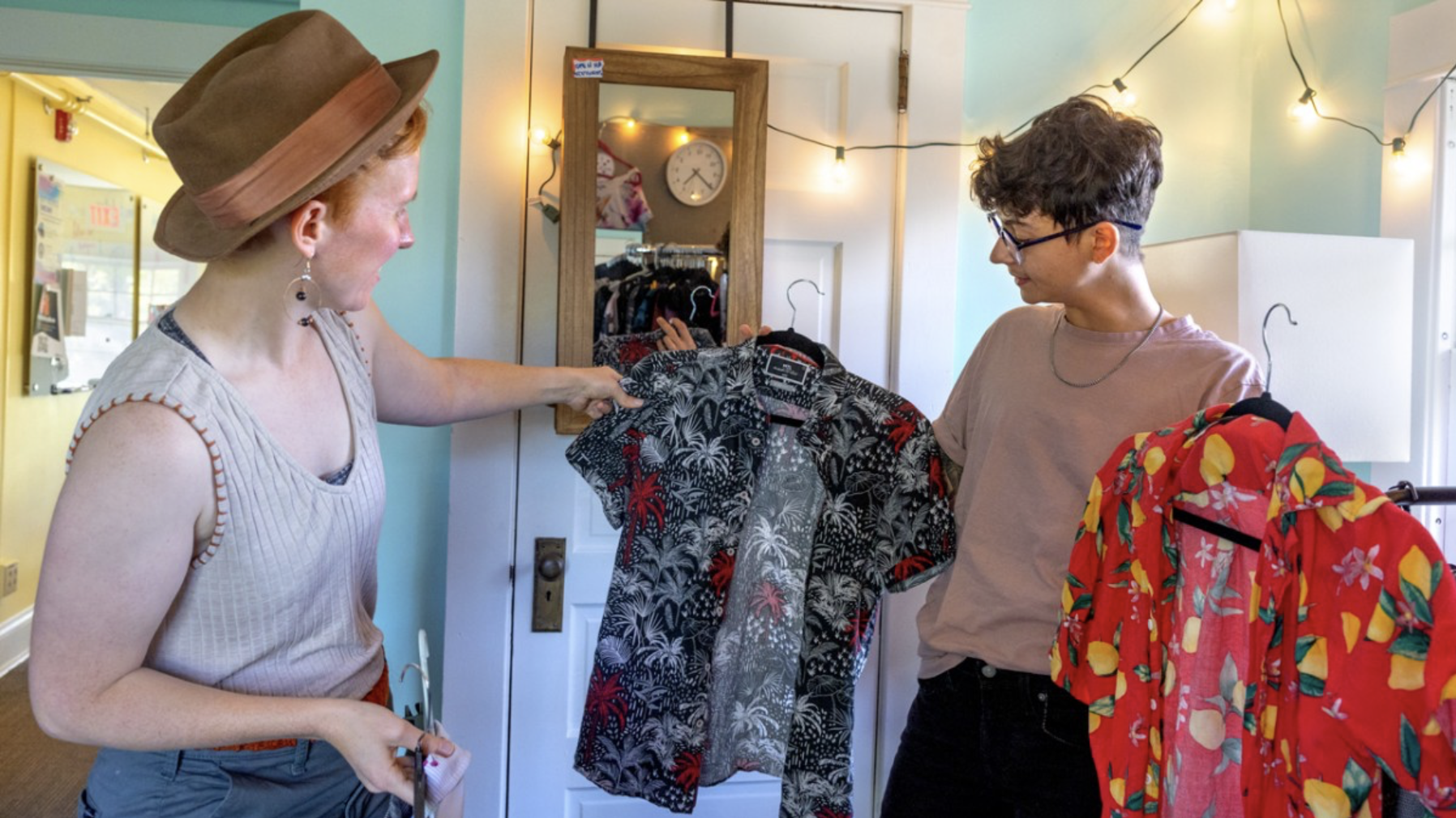 Two students look at clothing together.
