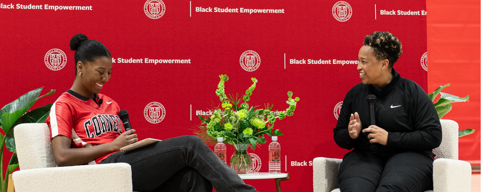 Jennifer King, first Black woman NFL coach, speaks on stage with a student at an event at Cornell.