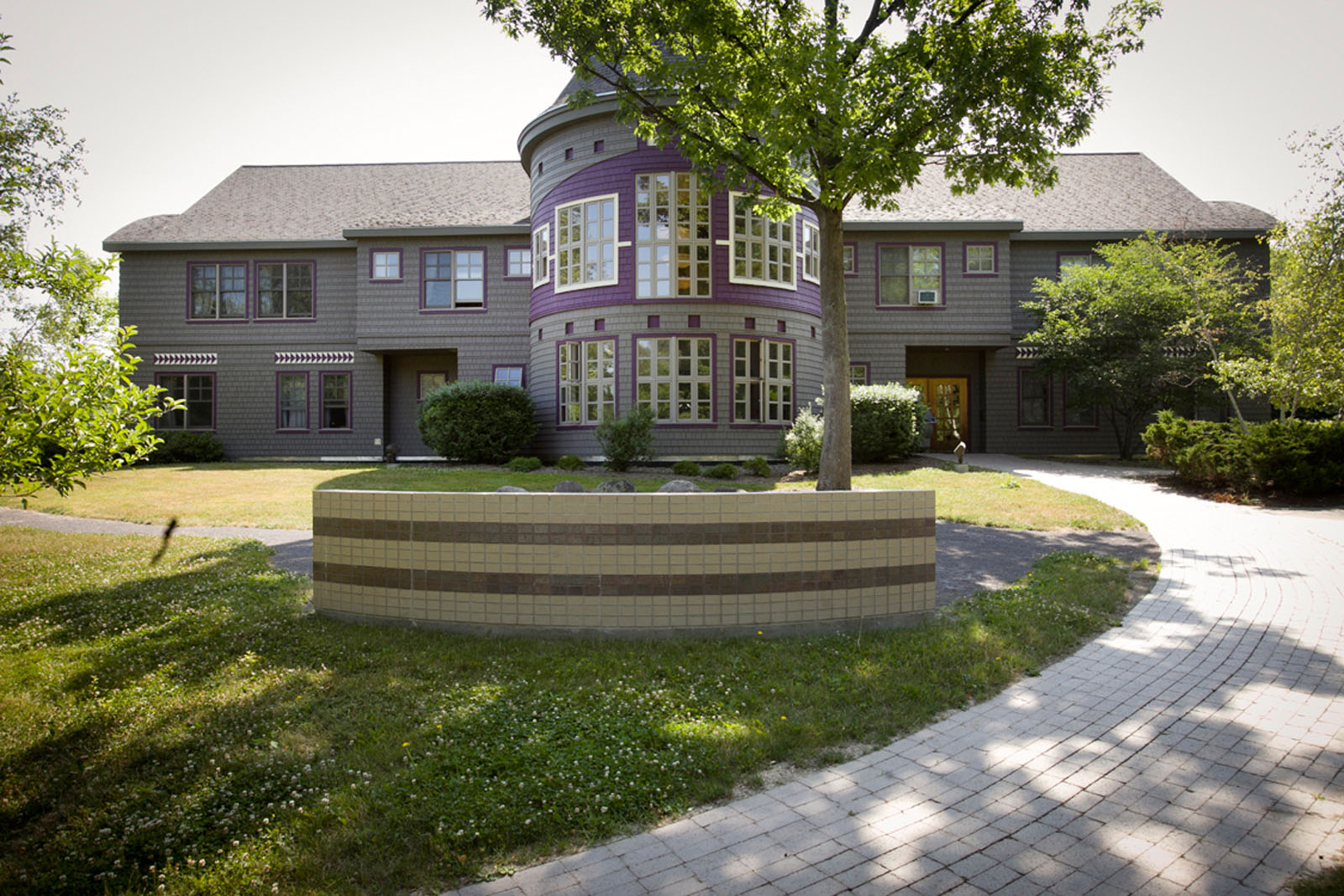 Exterior photo of Akwe:kon Program House surrounded by green trees on a sunny day