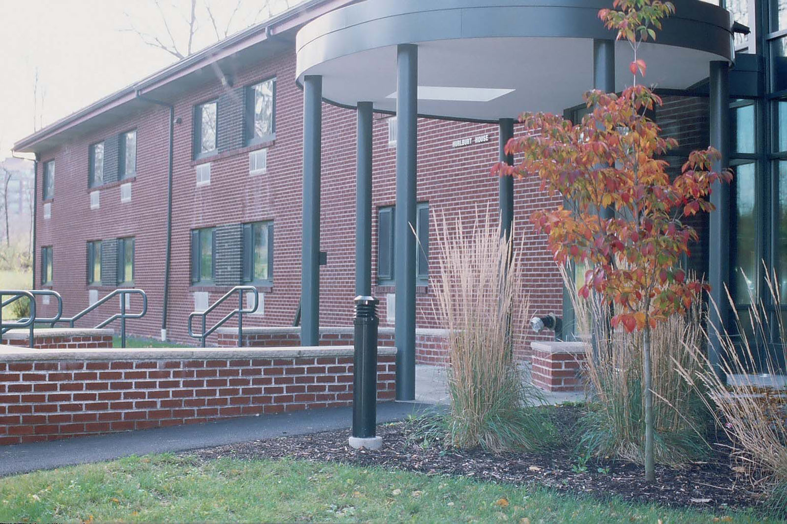 Covered entryway to a brick building for Eco House