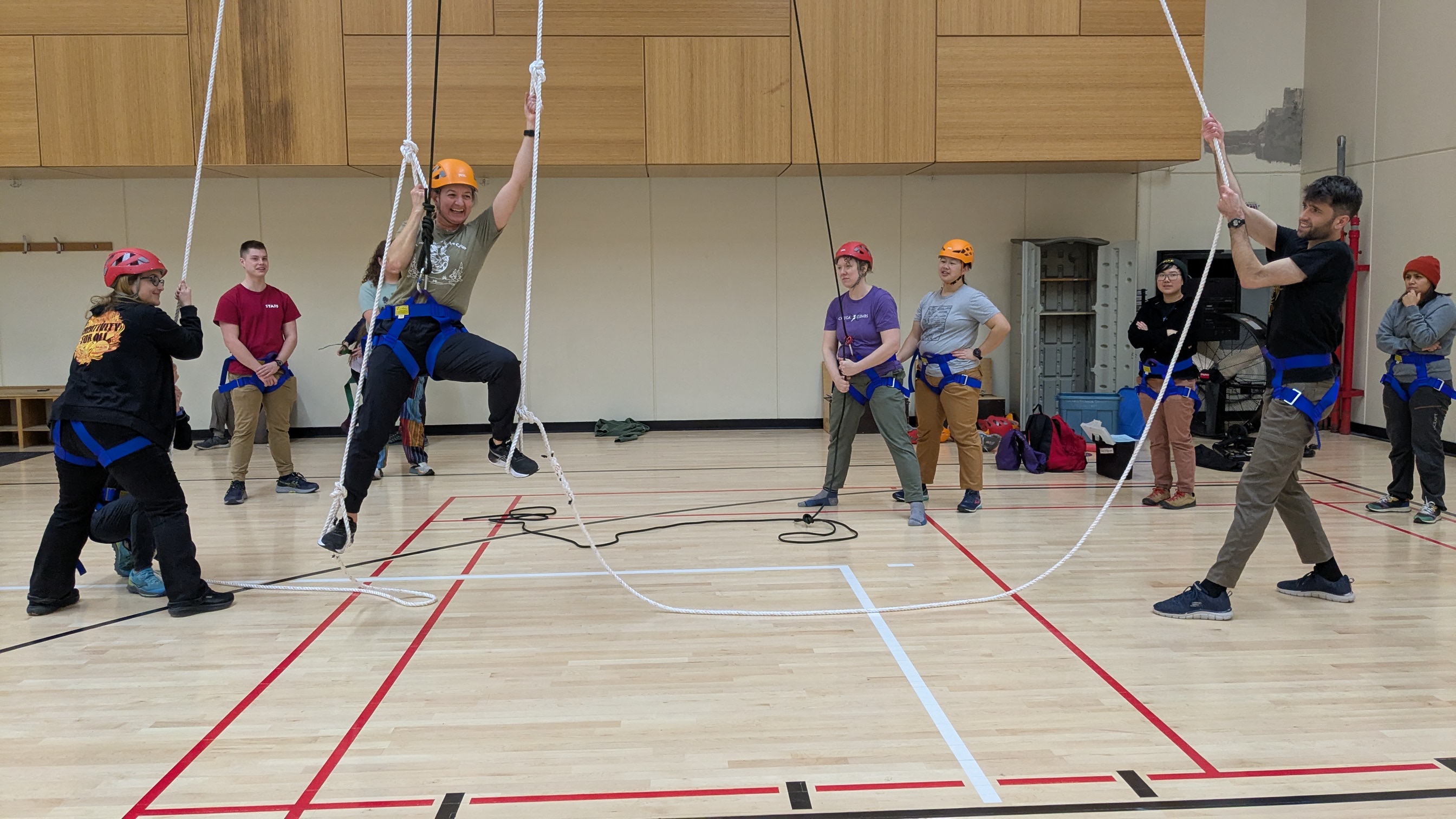 person climbing up ropes in gym