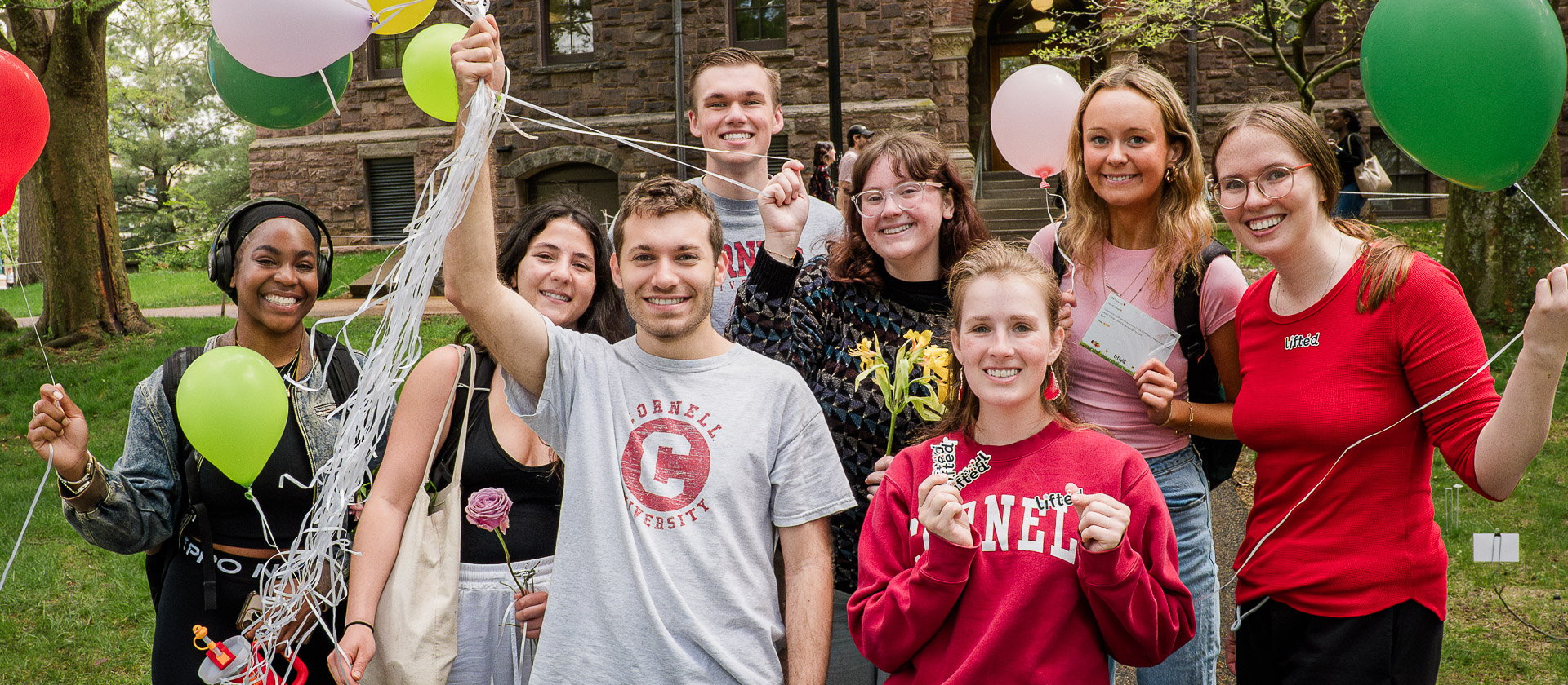 Group of Students Holding Balloons and Stickers Smiling outside