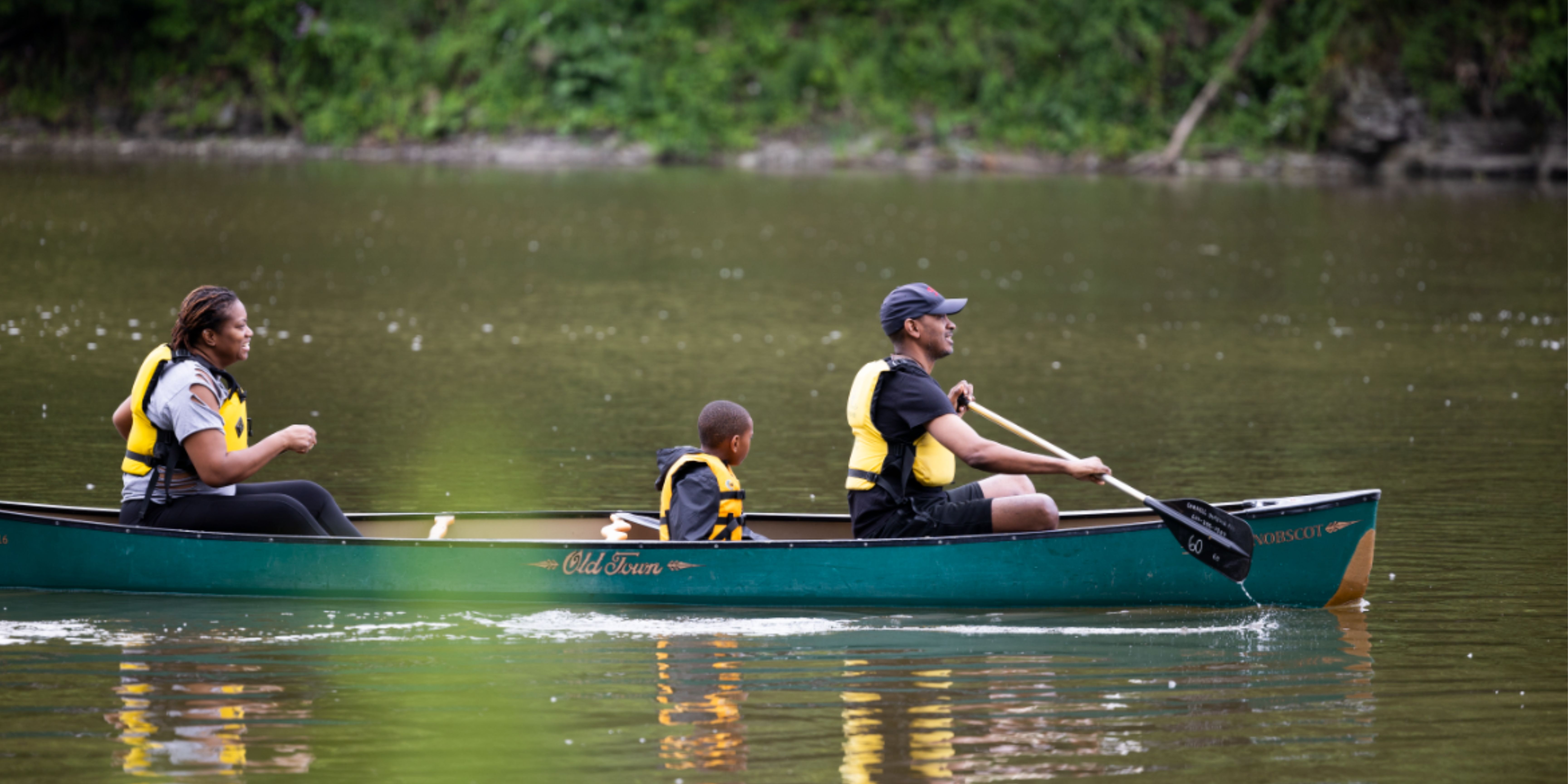 family of three in canoe on lake