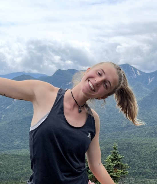 Sav outside with mountain in the background