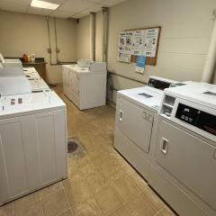 An apartment laundry room with multiple washers and dryers