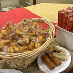A basket of fortune cookies and a bin of chopsticks in wrappers