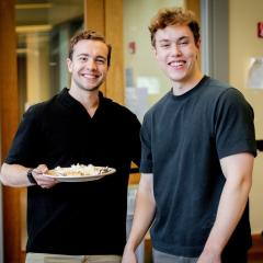 Two male identifying student in a dining room