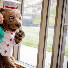 Touchdown celebrating with a student in a dining room