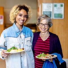 Two dining guests smiling and standing side by side