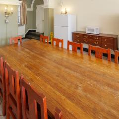 A large dining room with two long tables with chairs on either side.