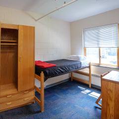 A bedroom in 109 McGraw Place with a twin bed, dresser, table, and chair.