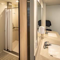 a shower behind the sinks and mirror