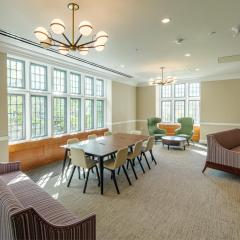 Lounge with couches, lounge chairs, and a long table with chairs.