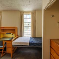 room with a bed, desk, chair, closet and dresser.