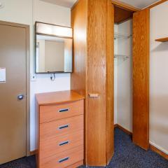 Set of drawers below a mirror next to a wardrobe on blue carpet.