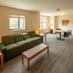 living room with a couch, two side tables, a coffee table, lamps and a dining table and chairs.