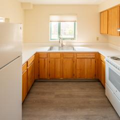 kitchen with wood cabinets, a stove, a sink and a fridge.