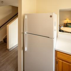 Kitchen with a fridge overlooking the living room and stairs.