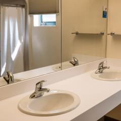 Two sinks, countertops, and a mirror that covers the entire wall.