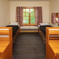 Bedrooms with two twin beds, dressers, desks, and chairs.