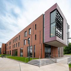 large angular building with sidewalk and green grass