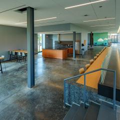 A large communal kitchen in Barbara McClintock Hall with countertops, a stove, a fridge, cabinets, a microwave, and many different tables and chairs.