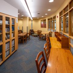 library with wooden tables and chairs as well as bookcases with books