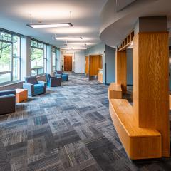 carpeted lounge with large windows and seating