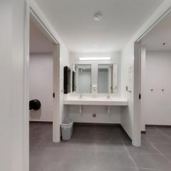 Sinks with a mirror above with the entrance to the showers on the sides.