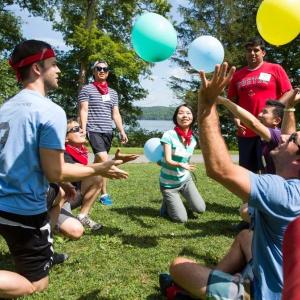 Johnson business students are trying to keep three balloons afloat on a summer day.