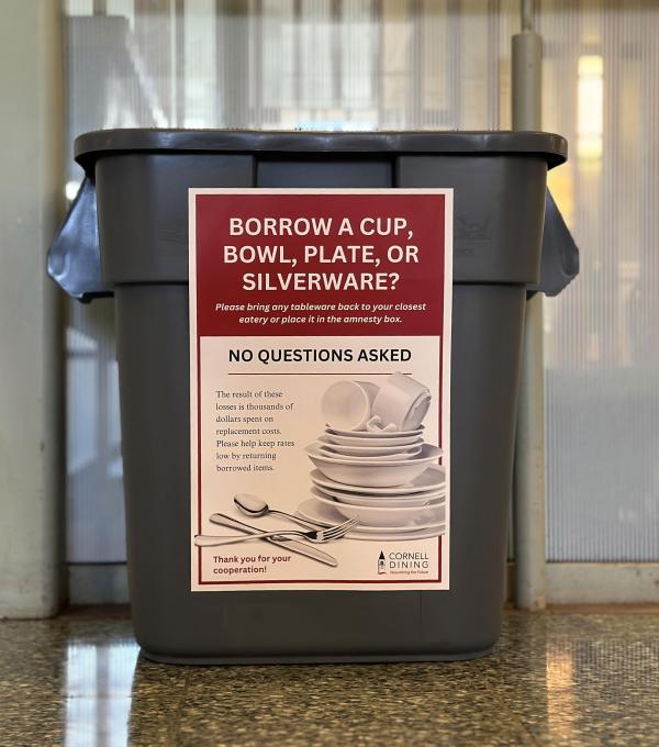 A bin sitting against a glass wall that says borrow a cup, bowl, plate, or silverware? Please bring any tableware back, no questions asked