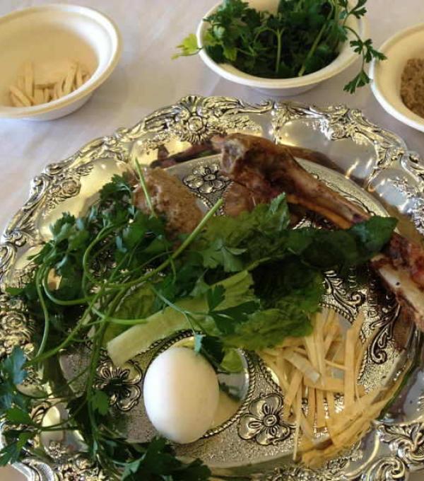 A seder plate with traditional Passover items on and around it