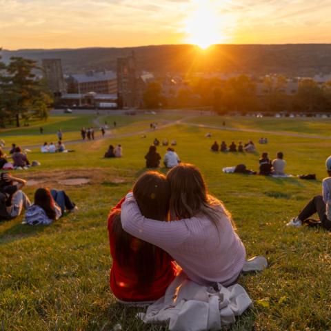 Students watch sunset on Libe Slope