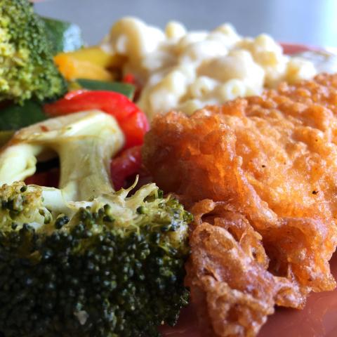 Fried fish with veggies and mac and cheese on a plate